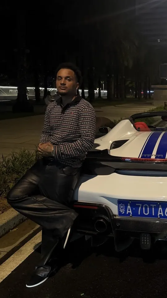 Mexed, appuyé sur une voiture de sport
